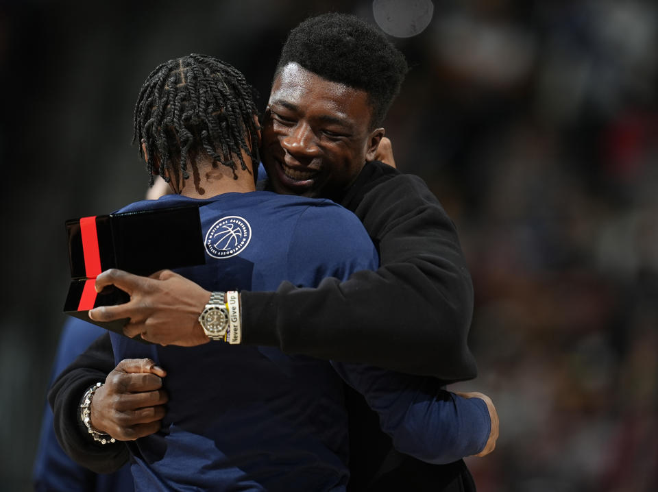 Miami Heat center Thomas Bryant, right, hugs Denver Nuggets guard Kentavious Caldwell-Pope, who gave Bryant his NBA championship ring during a ceremony before a basketball game Thursday, Feb. 29, 2024, in Denver. Bryant was a member of the Nuggets' team when they won the championship last season. (AP Photo/David Zalubowski)