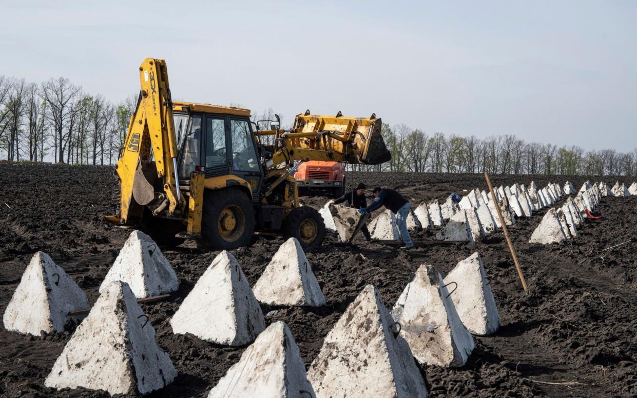 Workers install dragon teeth