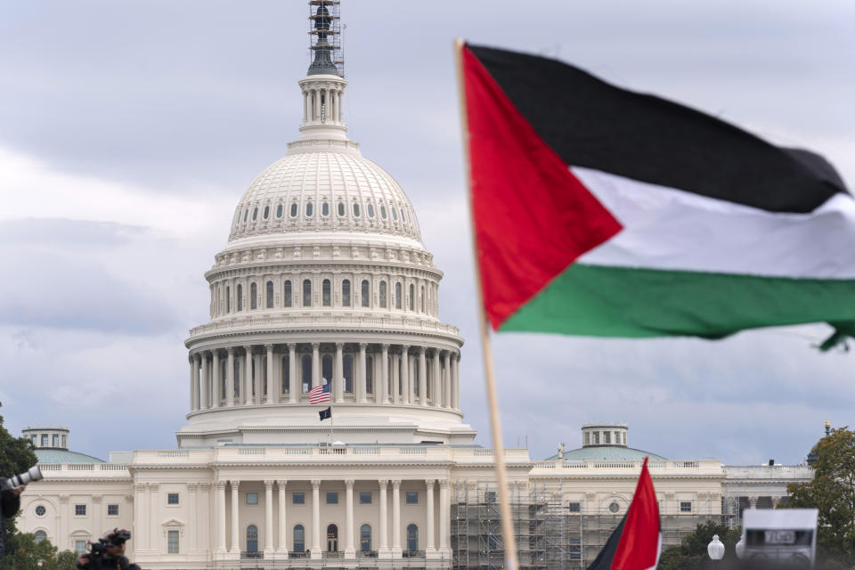 FILE - The U.S. Capitol is seen behind a Palestinian flag as people rally at the National Mall during a pro-Palestinian demonstration in Washington, Oct. 20, 2023. About half of Asian Americans, Native Hawaiians and Pacific Islanders in the U.S. believe the country is giving too much support of Israelis and not enough for Palestinians amid the ongoing war in Gaza, according to a new poll that shows those views are dominant among young adults. (AP Photo/Jose Luis Magana, File)