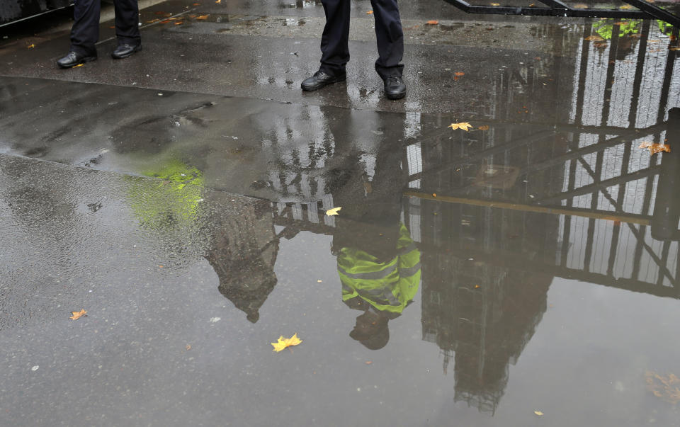 Police officers guarding the entrance to Britain's Parliament are reflected in a puddle in London, Friday, Sept. 27, 2019. U.K. interest rates could be cut even if the country avoids leaving the European Union on Oct. 31 without a deal, one of the Bank of England's nine top policymakers said Friday. (AP Photo/Kirsty Wigglesworth)