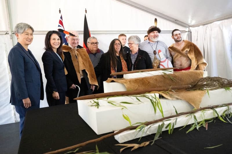 Annalena Baerbock (2-L), German Foreign Minister, Penny Wong (L), Foreign Minister of Australia, and representatives of the Kaurna people take part in a ceremony to repatriate cultural objects sent to Germany by German missionaries in the 19th century. The Grassi Museum in Leipzig had already brought them back to Australia last year. Foreign Minister Baerbock's week-long trip to Australia, New Zealand and Fiji will focus on security policy and climate protection. Sina Schuldt/dpa