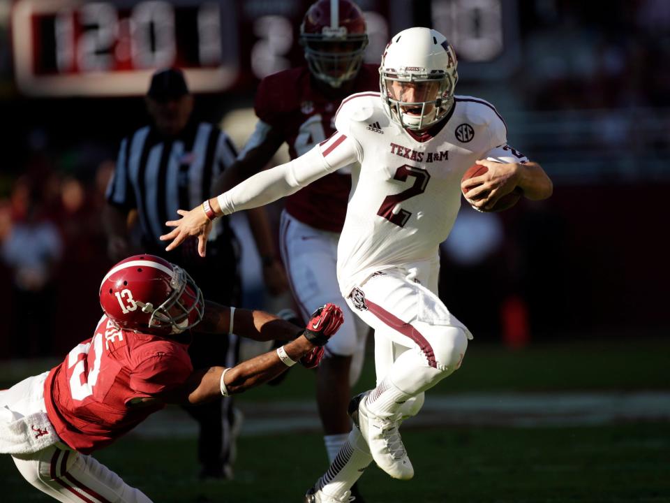 Johnny Manziel breaks a tackle from an Alabama defender.