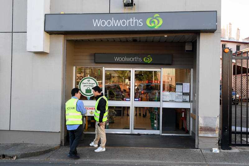 Cleaning contractors are seen at the Woolworths supermarket in Balmain, Sydney.