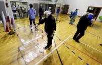 Voters cast their ballots shortly after polling stations open in Poland's tight presidential election runoff between conservative incumbent President Andrzej Duda and liberal Warsaw Mayor Rafal Trzaskowski, in Lomianki, near Warsaw, Poland, on Sunday, July 12, 2020. Latest polls showed that the race may be decided by a very small margin. (AP Photo/Czarek Sokolowski)