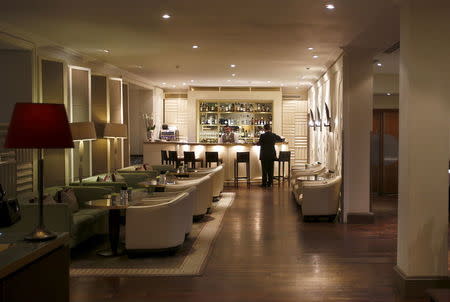 A barman stands behind the bar of the Cocktail Bar in the clubhouse of the Wentworth Club in Virginia Water, Britain, January 8, 2016. REUTERS/Peter Nicholls