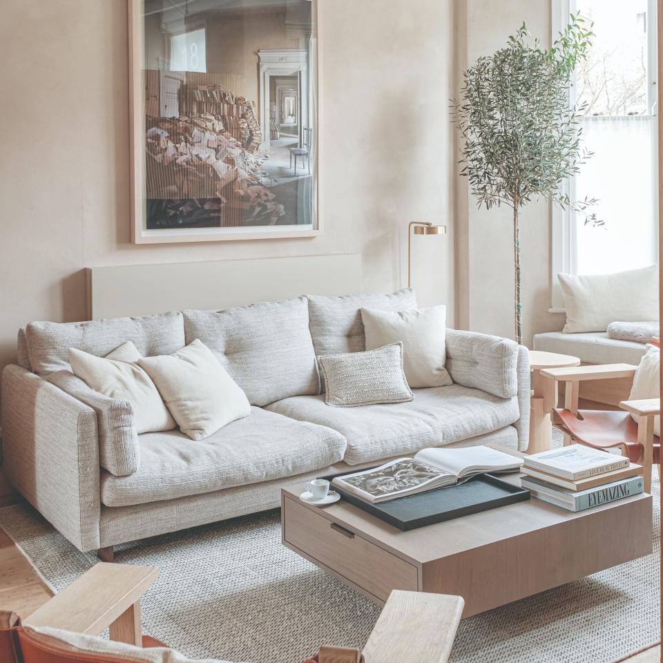 A neutral-coloured living room with a deep cream sofa and a storage coffee table with drawers