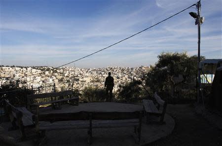 An Israeli soldier overlooks the divided city of Hebron in the occupied West Bank as he stands near an archaeological site in the Jewish settler neighbourhood of Tel Rumeida, January 19, 2014. REUTERS/Ronen Zvulun