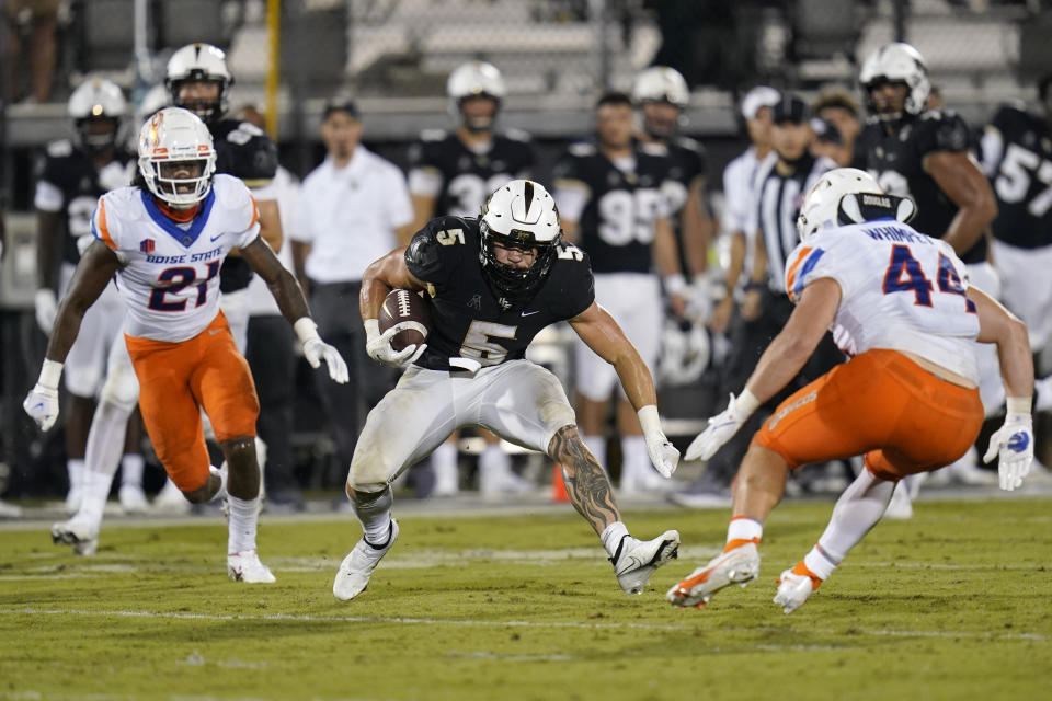 Central Florida running back Isaiah Bowser (5) looks for a way past Boise State safety Tyreque Jones (21) and linebacker Riley Whimpey (44) during the second half of an NCAA college football game Friday, Sept. 3, 2021, in Orlando, Fla. (AP Photo/John Raoux)