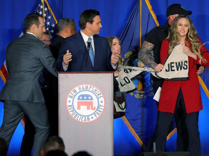 Demonstrators interrupt Florida Governor Ron DeSantis as he speaks at the 2023 NHGOP Amos Tuck Dinner in Manchester, New Hampshire, U.S., April 14, 2023.