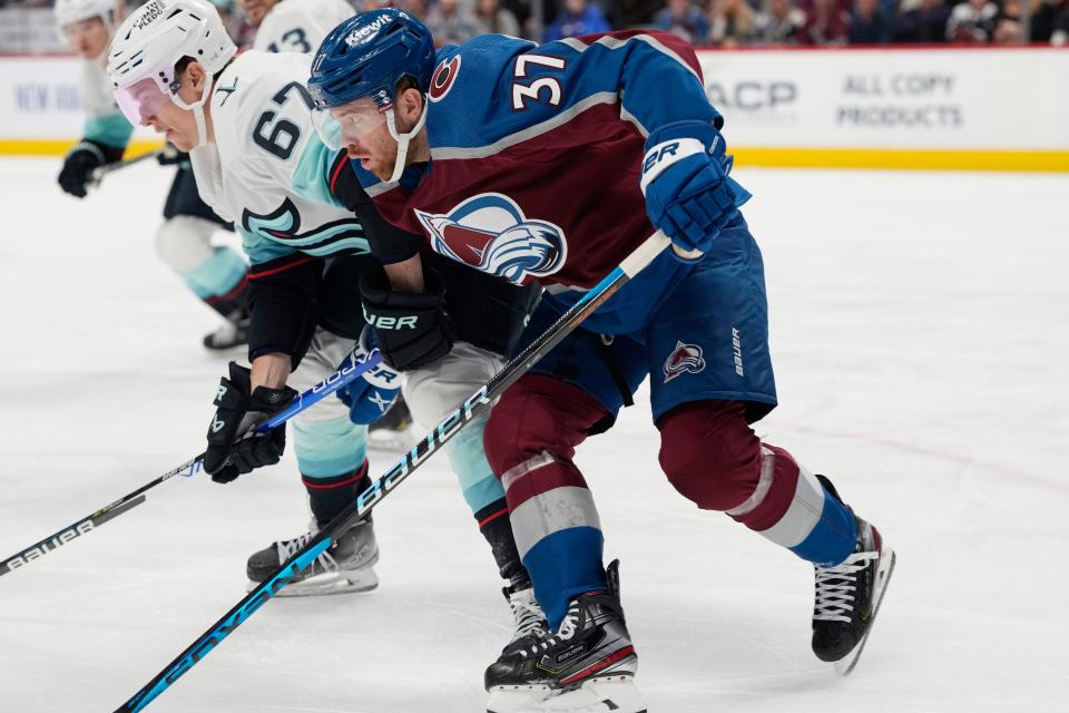 Colorado Avalanche left wing J.T. Compher (37) and Seattle Kraken center Morgan Geekie (67) in the first period of an NHL hockey game Sunday, March 5, 2023, in Denver.