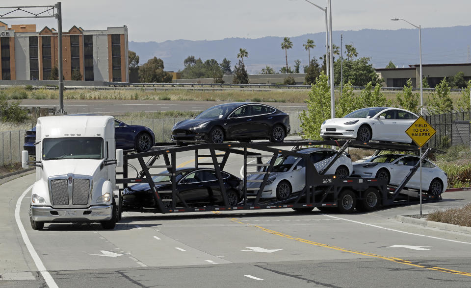 A truck hauling new Tesla vehicles leaves the Tesla factory plant on Monday, May 11, 2020, in Fremont, Calif. The parking lot was nearly full at Tesla's California electric car factory Monday, an indication that the company could be resuming production in defiance of an order from county health authorities. (AP Photo/Ben Margot)