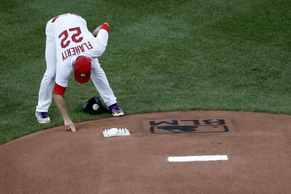 St. Louis Cardinals pitcher Jack Flaherty touches the mound near a Black Lives Matter logo before starting a baseball game against the Pittsburgh Pirates Friday, July 24, 2020, in St. Louis. (AP Photo/Jeff Roberson)