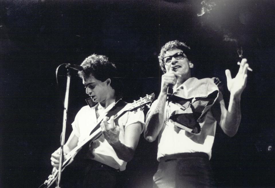 Marty Lee Hoenes, left, plays guitar with Donnie Iris and the Cruisers during a concert in the band's earlier years.