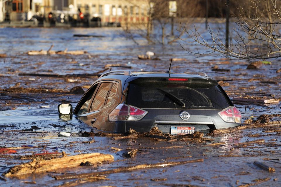 A car floats in a flooded parking lot at the Hathaway Creative Center alongside the Kennebec River in Waterville, Maine. A severe storm on Monday flooded rivers and knocked out power to hundreds of thousands. (AP Photo/Robert F. Bukaty)