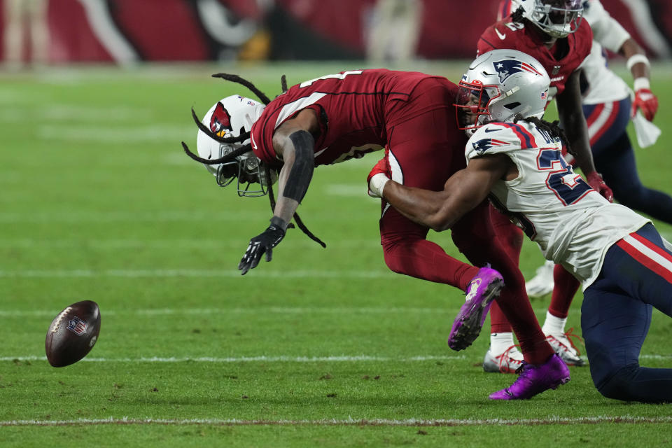 Arizona Cardinals wide receiver DeAndre Hopkins (10) fumbles the ball while tackled by New England Patriots safety Kyle Dugger (23) during the second half of an NFL football game, Monday, Dec. 12, 2022, in Glendale, Ariz. (AP Photo/Ross D. Franklin)