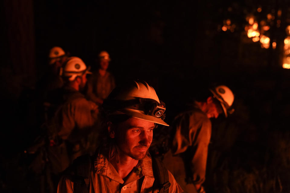 Firefighters take a break while setting a backfire to prevent the Caldor Fire from spreading near South Lake Tahoe, Calif., Wednesday, Sept. 1, 2021. (AP Photo/Jae C. Hong)