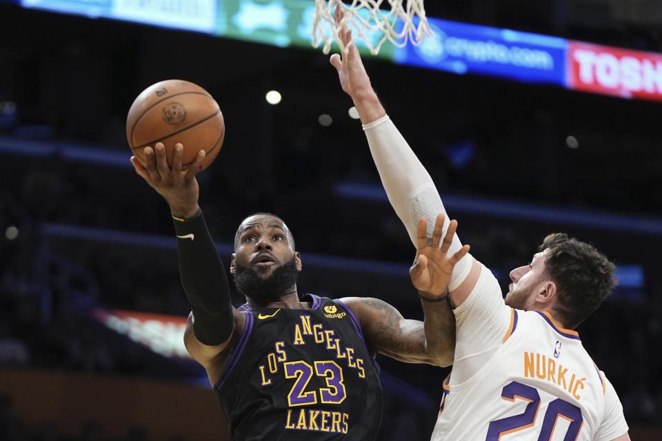 Los Angeles Lakers forward LeBron James shoots as Phoenix Suns center Jusuf Nurkić defends during the first half the NBA in-season tournament quarterfinal game on Dec. 5, 2023, in Los Angeles. (AP Photo/Mark J. Terrill)