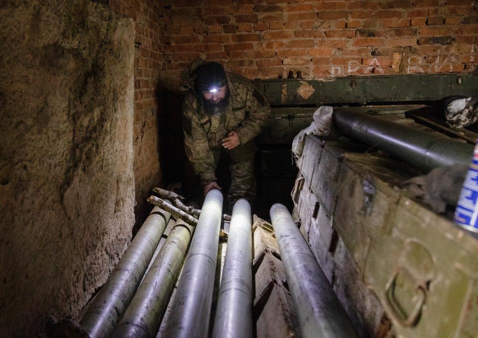 Ukrainian servicemen prepare rockets to shoot from a self-made multiple rocket launcher on a frontline in Donetsk (EPA)