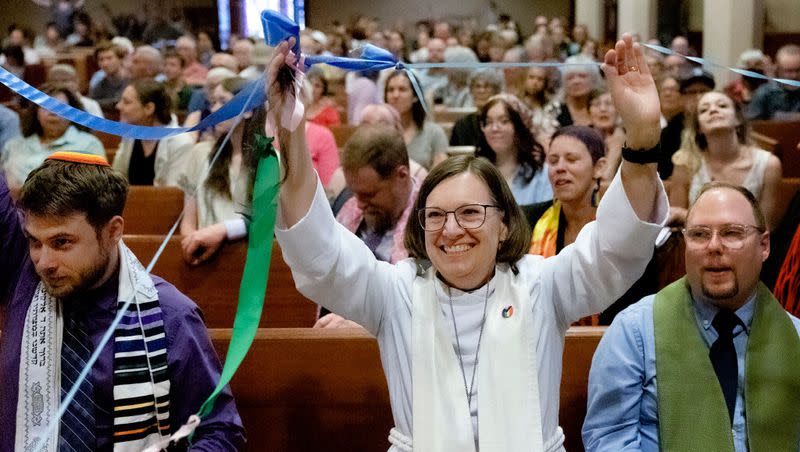 Rabbi Samuel Spector, Rev. Brigette Weier and Pastor Tyler Marz hold up a ribbon encircling the entire congregation during the Utah Pride Interfaith Coalition Interfaith Service at the First Baptist Church in Salt Lake City on Wednesday.