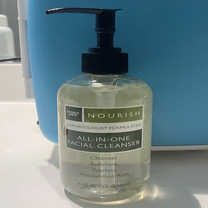 A bottle of facial cleanser sits on a countertop