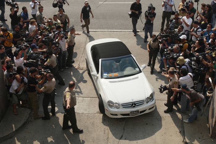 Britney being driven as fans and paparazzi take photos of her