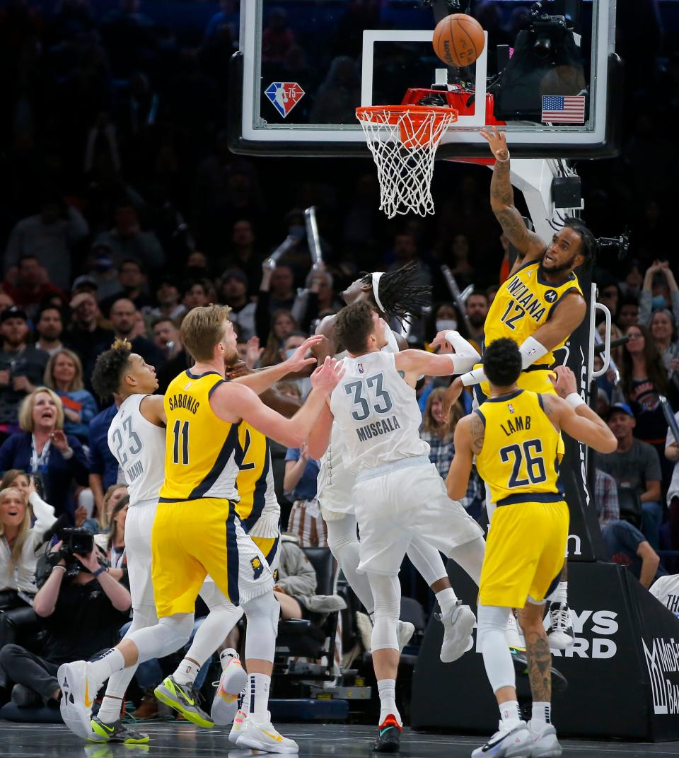 Pacers forward Oshae Brissett (12) knocks the ball back out in the final seconds of overtime Friday at Paycom Center. Indiana beat OKC 113-110.