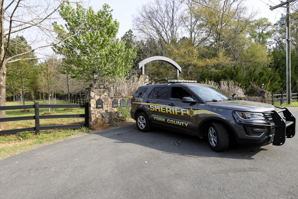 A York County sheriff's deputy is parked outside a residence where multiple people, including a prominent doctor, were fatally shot a day earlier, Thursday, April 8, 2021, in Rock Hill, S.C. A source briefed on the mass killing said the gunman was former NFL player Phillip Adams, who shot himself to death early Thursday. (AP Photo/Nell Redmond)
