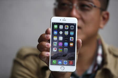 Tony Zhan, 32, holds up his new iPhone 6 Plus after it went on sale at the Apple store in Pasadena, California September 19, 2014. REUTERS/Lucy Nicholson