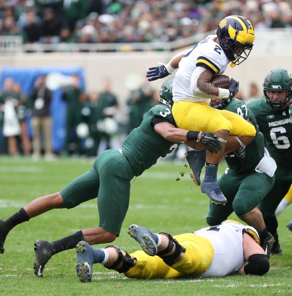 Michigan Wolverines running back Blake Corum is tackled by Michigan State Spartans safety Xavier Henderson (3) during the first half Saturday, Oct. 30, 2021.