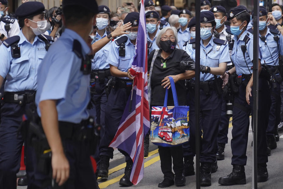 A protester holding a U.K. flag is arrested by police officers during the 24th anniversary of Hong Kong handover to China at a street in Hong Kong Thursday, July 1, 2021. (AP Photo)