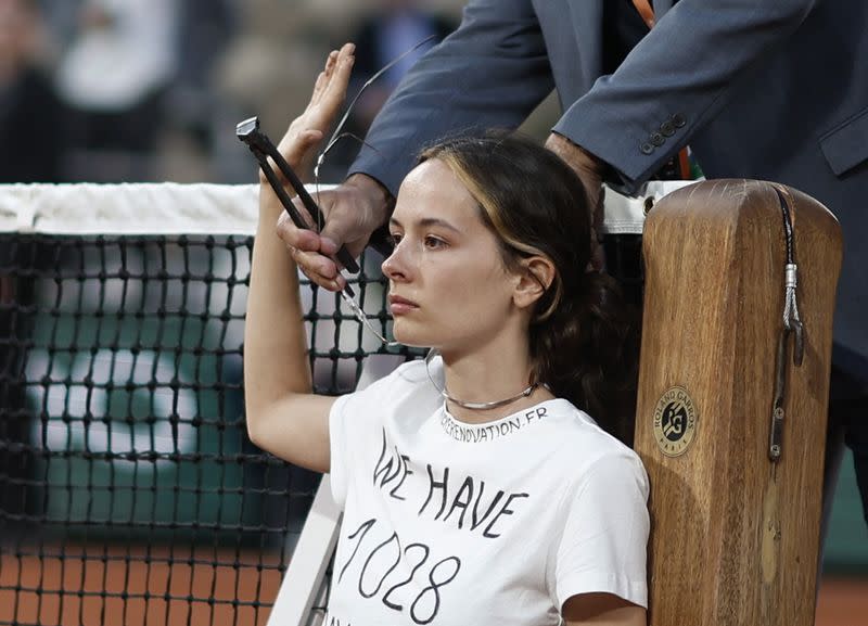 Foto del jueves de una manifestante atada a la red en la semifinal de Roland Garros entre Casper Ruud y Marin Cilic