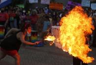 A fire breather burns a poster with the word "Patriarchy" during a march commemorating Women's International Day in Asuncion, Paraguay, Monday, March 8, 2021. (AP Photo/Jorge Saenz)