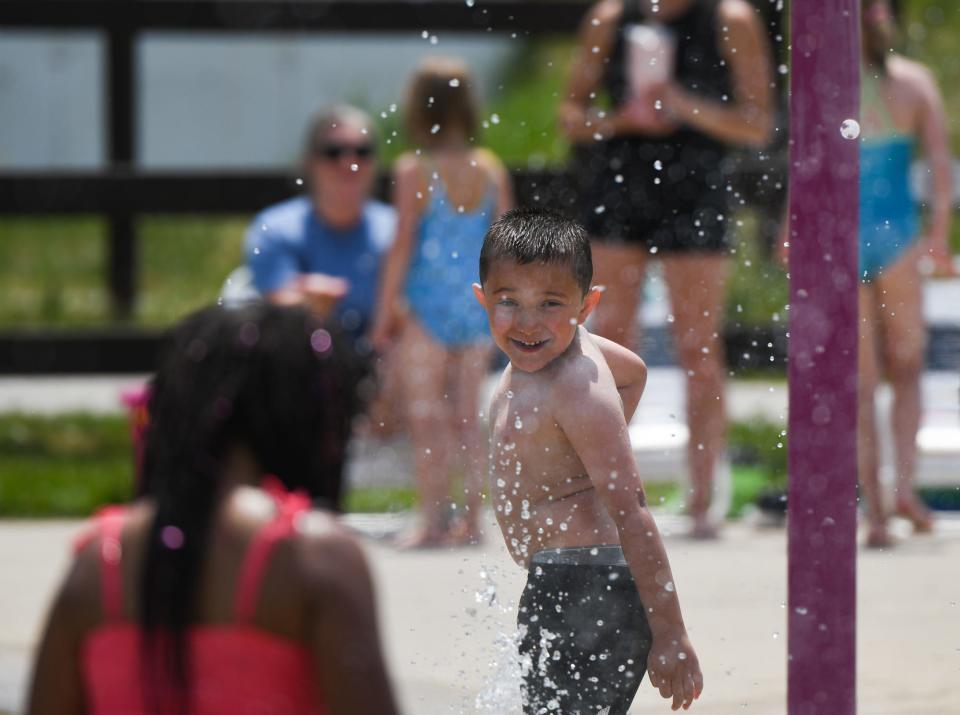 Gabriel Barbour, 6, of Lansing, plays at the Hawk Island splash pad, Friday, June 2, 2023, as temperatures in the Lansing area reach 91 degrees Farenheit.