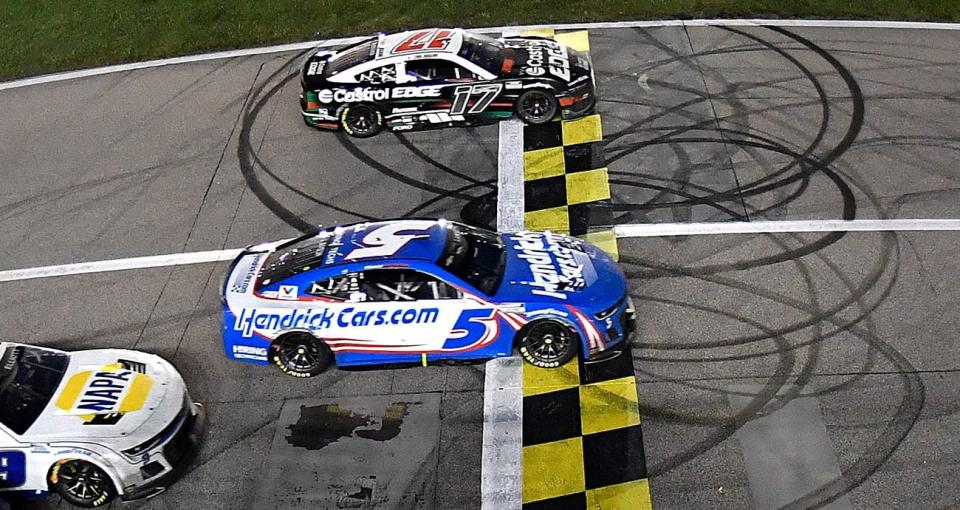 Kyle Larson and Chris Buescher cross the finish line at Kansas Speedway.