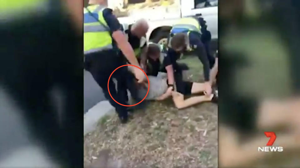 A police officer appears to strike Murphy in the face with his boot. Source: 7News