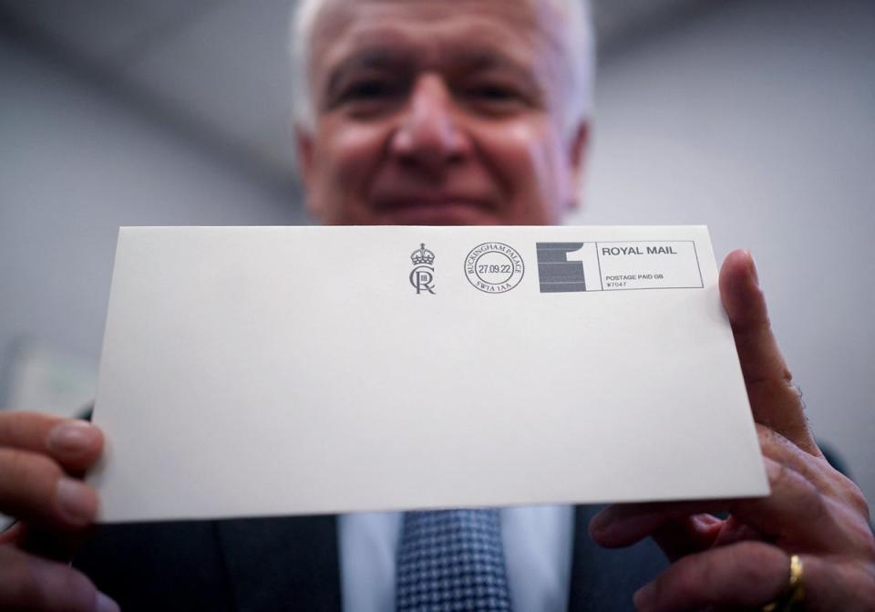 27 September 2022: David White, Garter King of Arms, poses with an envelope franked with the new cypher of King Charles III 'CIIIR', after it was printed in the Court Post Office at Buckingham Palace in central London (AFP/Getty)