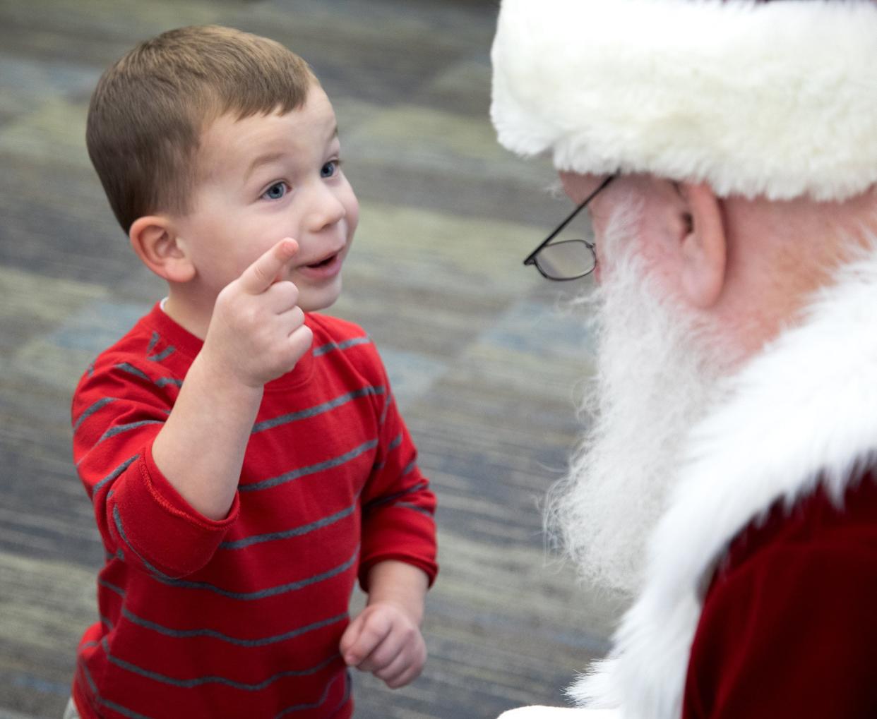 Ayden Caudill talks with Santa at the Canal Fulton Library during the Christmas on the Canal celebration Saturday, Dec. 4, 2021. The event was canceled last year because of the COVID-19 pandemic. The event featured children's activities, an ice carver and an evening electric-light parade.