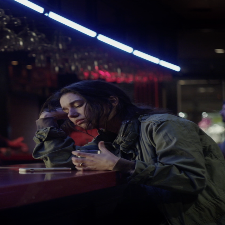 A girl drinks alone in a bar