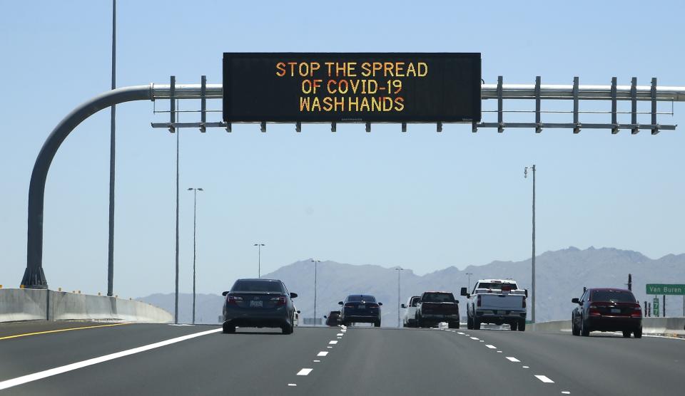 The Arizona Department of Transportation posts new signage on along highways urging the public to wash hands due to the recent surge in coronavirus cases Sunday, June 21, 2020, in Phoenix. (AP Photo/Ross D. Franklin)