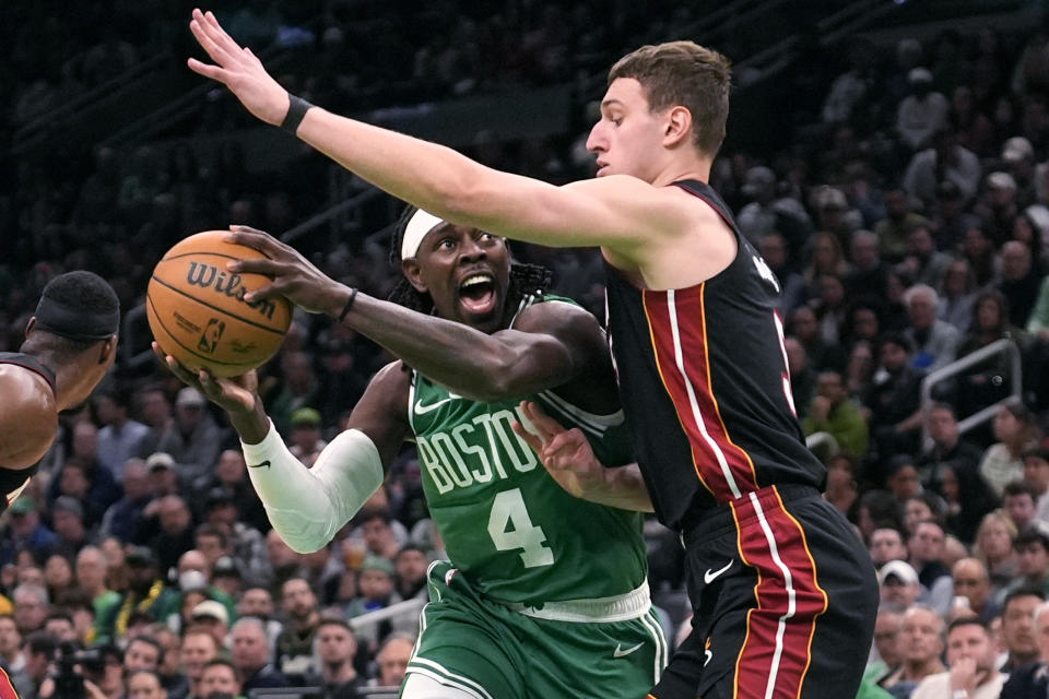 Boston Celtics guard Jrue Holiday (4) is pressured by Miami Heat forward Nikola Jovic, right, during the first half of Game 2 of an NBA basketball first-round playoff series, Wednesday, April 24, 2024, in Boston. (AP Photo/Charles Krupa)