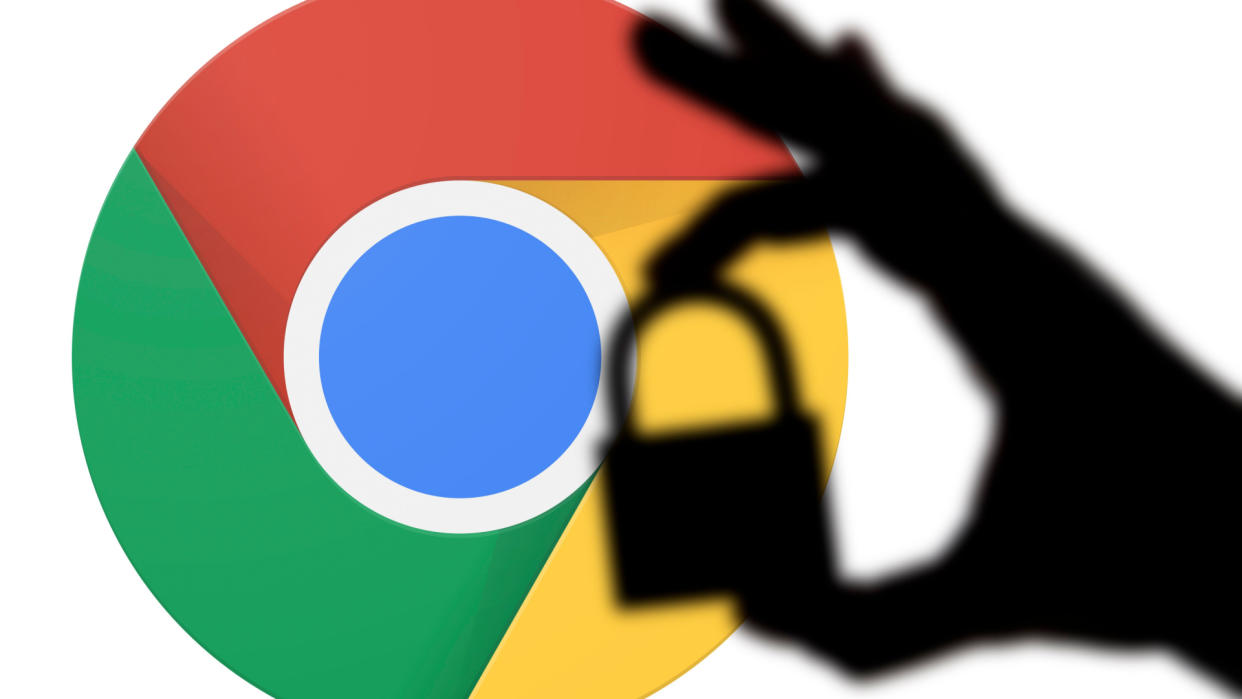  Silhouette of a hand holding a padlock infront of the google chrome logo 