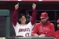 Los Angeles Angels designated hitter Shohei Ohtani, left, gestures from the dugout toward Jack Mayfield after Mayfield hit an RBI single during the seventh inning of a baseball game against the Seattle Mariners Friday, Sept. 24, 2021, in Anaheim, Calif. (AP Photo/Mark J. Terrill)