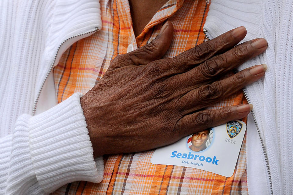 NEW YORK, NY - SEPTEMBER 11: Hattie Wilson places her hand over her heart during the singing of the National Anthem as she mourns her nephew Det. Joseph Seabrook during memorial observances held at the site of the World Trade Center on September 11, 2014in New York City. This year marks the 13th anniversary of the September 11th terrorist attacks that killed nearly 3,000 people at the World Trade Center, Pentagon and on Flight 93.  (Photo by Robert Sabo- Pool/Getty Images)