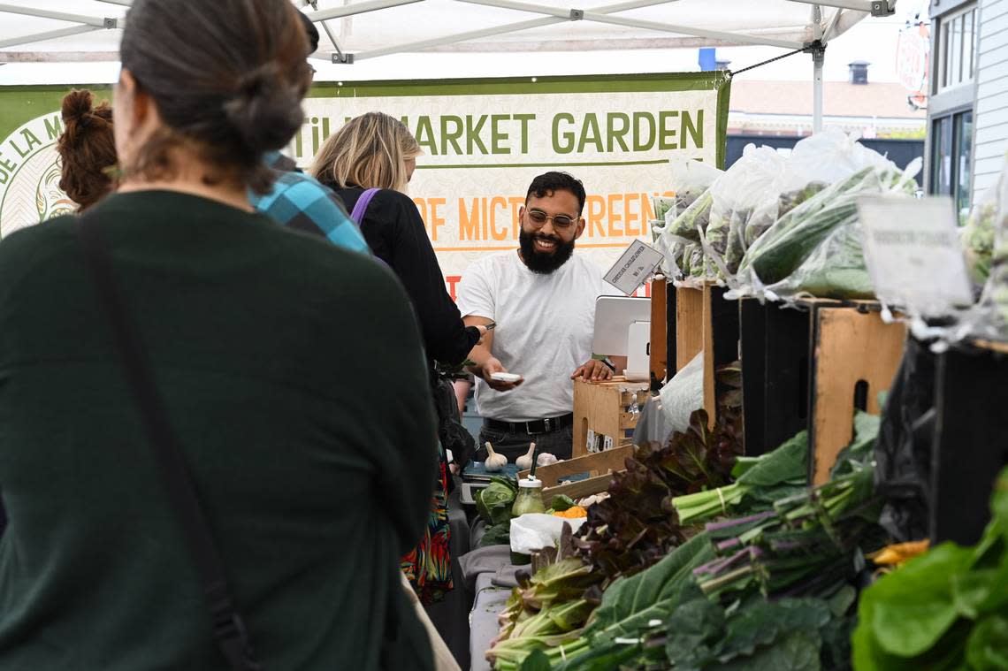 Customers line up to buy produce from the De La Mesa Farms booth at the Proctor Farmers Market on Aug. 10 near Tacoma. De La Mesa Farms uses no-till regenerative and indigenous farming practices and has incorporated cover crops into their farming routine for ten years.