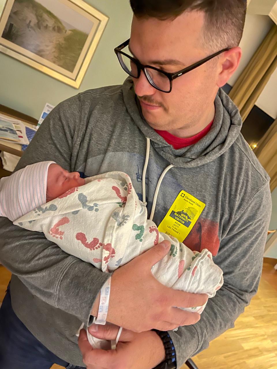 Port St. Lucie Police Officer Adam Doty poses with his newborn baby on Friday, Feb. 4, 2022, just a few days after he helped save a man who was drowning in a Port St. Lucie pond.