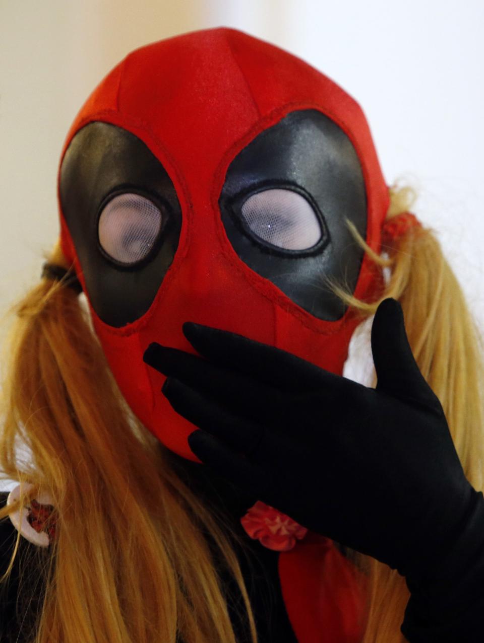 A woman dressed in the costume of Marvel Comics character "Deadpool" poses for a photograph at Comic-Con Russia convention and IgroMir 2014 exhibition in Moscow, October 3, 2014. REUTERS/Sergei Karpukhin (RUSSIA - Tags: ENTERTAINMENT SOCIETY)