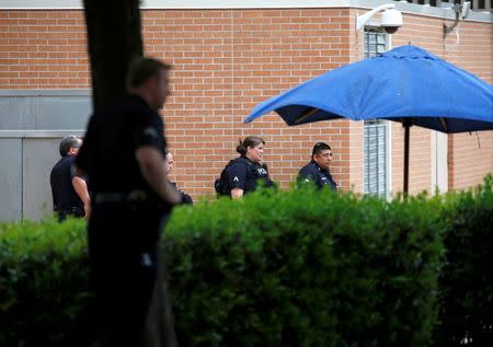 Dallas police officers stand outside Dallas Police Department headquarters during a lockdown after an anonymous threat was reported in Dallas, Texas, U.S. July 9, 2016. REUTERS/Carlo Allegri