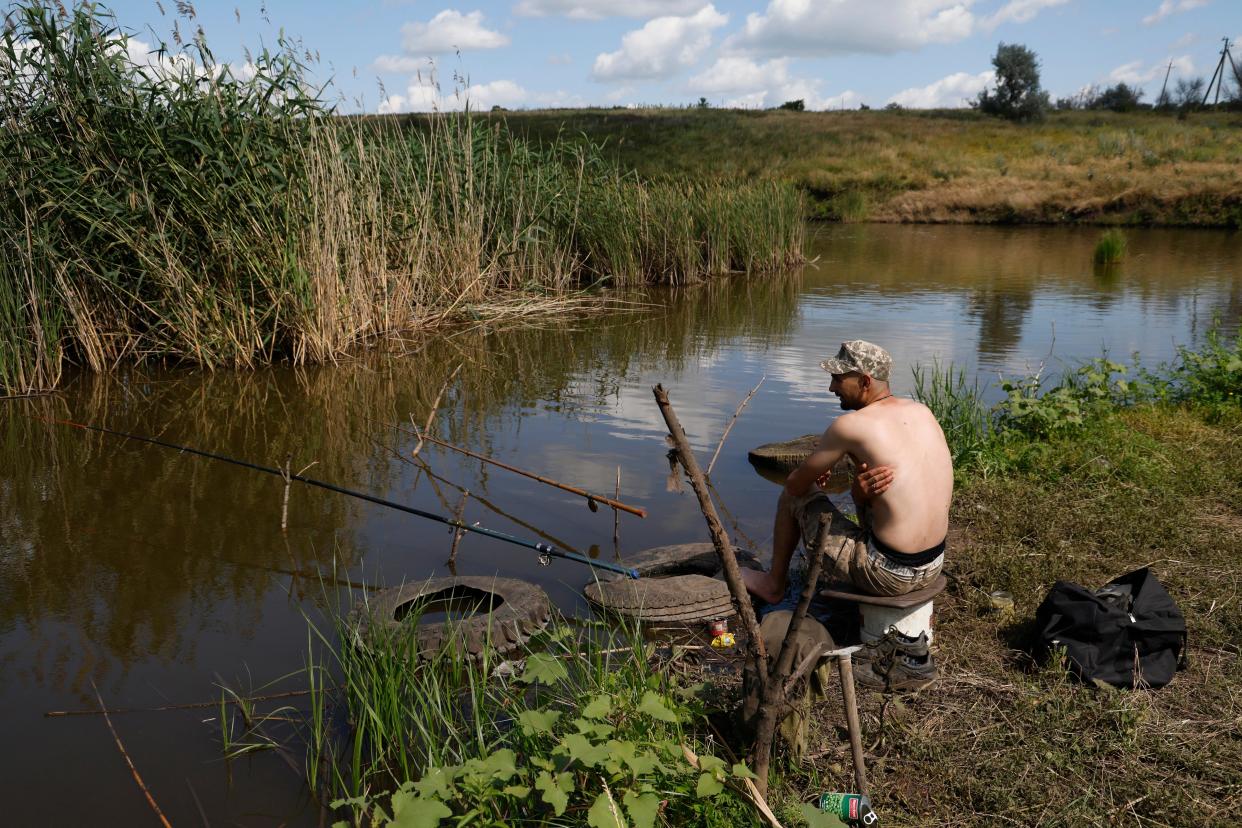 A Ukrainian serviceman fishes in a lake while resting at an area near the frontline city of Bakhmut, Donetsk region (EPA)