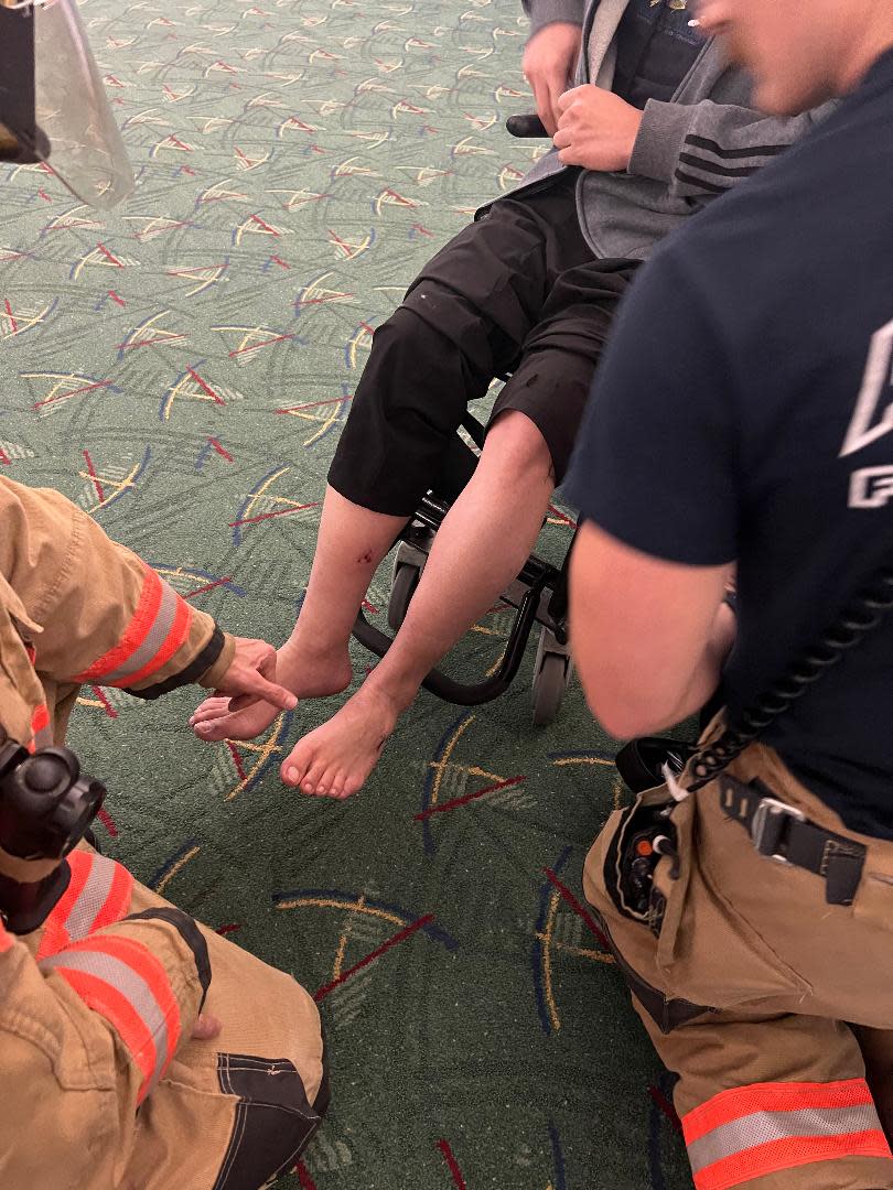 Medical personnel look examine Cuong Tran's injured foot after the emergency landing of Alaska Airlines Flight 1282 on Jan. 5, 2024.