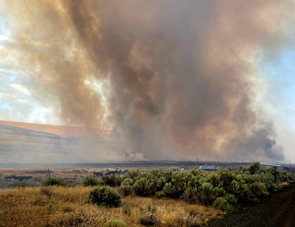 RETRANSMISSION TO CORRECT STATE - This photo provided by the Washington State Department of Transportation shows smoke from a wildfire burning south of Lind, Wash. on Thursday, Aug. 4, 2022. Sheriff's officials are telling residents in the town of Lind in eastern Washington to evacuate because of a growing wildfire south of town that was burning homes. (Washington State Department of Transportation via AP)